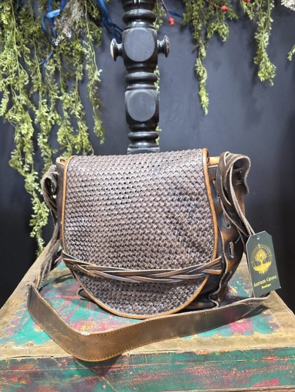 Woven leather crossbody bag on a display stand